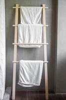 närbild ren badrock och handduk hängande i trä garderob på lyxhotell. koppla av och resa koncept foto