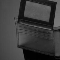 en närbild av en fashionabel läderplånbok på en mörk bakgrund foto
