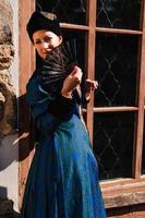 porträtt av kvinna klädd i blå historiska barockkläder med gammaldags frisyr, utomhus. foto