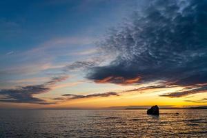 solnedgång vid thurlestone rock, south milton sands i devon foto