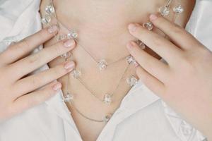 ung kvinna som bär kristall halsband, beskära vy. foto