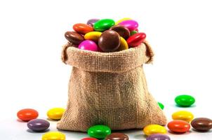 färgglada choklad godis i mini säck påse på vit bakgrund foto