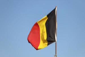 Belgien flagga vajar på flaggstång foto