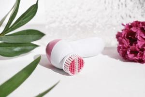 framifrån av rosa elektrisk ansiktsrengöringsborste. kosmetiskt verktyg för ansiktsvård, skrubbning, exfoliering, borttagning av pormaskar, massage. själv- och skönhetsvårdsrutinenhet foto