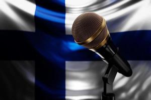 mikrofon på bakgrunden av Finlands nationella flagga, realistisk 3d-illustration. musikpris, karaoke, radio och ljudutrustning för inspelningsstudio foto