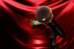 mikrofon på bakgrunden av Marockos nationella flagga, realistisk 3d-illustration. musikpris, karaoke, radio och ljudutrustning för inspelningsstudio foto