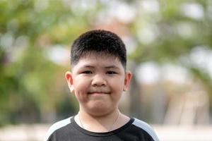 porträtt av söta asiatiska barn lilla thailändska pojke leende gör ett lyckligt ansikte koncept. foto