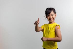 covid 19 vacciner för barn koncept. studio ett porträtt av en bedårande asiatisk tjej efter att ha fått sin första dos vaccin. immun, säker, tillgänglig, tillbaka till skolan. foto