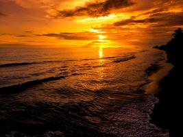 dramatiska gyllene solnedgångslandskap i havet foto