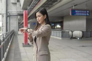 affärskvinna använder smart klocka i modern stad, affärsteknik, stadslivsstilskoncept foto