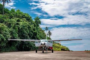 liten jet plan parkering i den lilla ön thailand med berg bakom. foto