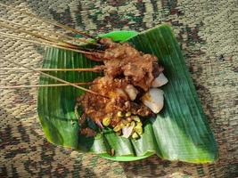 sate padang, indonesisk mat padang nötkött, tarmsatay med kryddig jordnötssås och riskaka foto