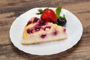 cheesecake med körsbär serveras jordgubbar foto