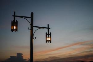 vintage gammal lampa i skymningen, solnedgångslampa, blå himmel foto