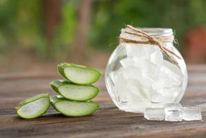 aloe vera på produkten display trä disk bakgrund. aloe vera är tropiska gröna växter. skivad aloe vera naturlig organisk förnyelse kosmetika, alternativ medicin. ekologisk hudvård koncept. foto