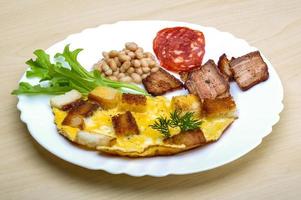 frukost med ägg, bacon och bönor foto