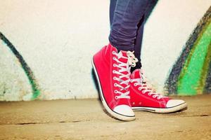 närbild av röda sneakers som bärs av en tonåring. foto