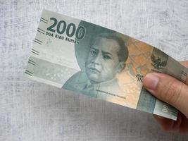 transaktionspengar i valören 2000 rupiah, den officiella indonesiska valutan foto