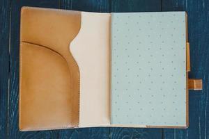 läder handgjorda anteckningsbok arrangör på mörk trä bakgrund foto