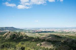 vackert landskap från en kulle vid los cerros park, i alcala de henares. utsikt över Madrids silhuett och bergen med snö i fjärran. madrid foto