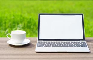 laptop och cofree kopp på trä bord agent gräsfält foto