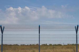 bur staket i fält, blå himmel bakgrund foto