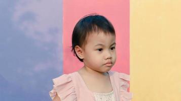 3 år gammal söt baby asiatisk flicka, litet småbarnsbarn på pastellvägg. foto