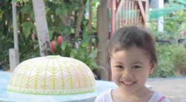 asiatisk liten flicka ler glatt utomhus, thailand. barn känslor koncept. foto