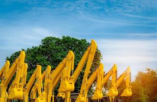 gul grävskopa med hydraulisk kolvarm. enorm metall bulldozer. grävmaskin. hydrauliska maskineri. tung maskinindustri. maskinteknik. lager av traktorgrävare vid fabriksparkering. foto