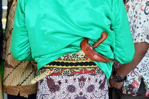 beskap är en indonesisk traditionell klänning för det javanesiska folket. keris är ett traditionellt javanesiskt vapen som vanligtvis är instoppat i en beskap. används vanligtvis för traditionella evenemang som bröllop. foto