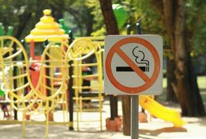 ingen rökning skylt nära lekplats i offentlig park foto
