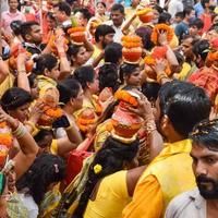 New Delhi, Indien 3 april 2022 - kvinnor med kalash på huvudet under jagannath-templet mangal kalash yatra, indiska hinduistiska hängivna bär jordkrukor som innehåller heligt vatten med en kokosnöt på toppen foto