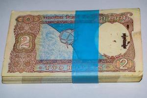 gamla två rupier sedlar kombinerade på bordet, indiska pengar på det roterande bordet. gamla indiska valutasedlar på ett roterande bord, indisk valuta på bordet foto