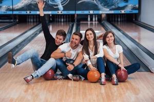 kille ha kul med armarna upp. unga glada vänner har kul i bowlingklubben på sina helger foto