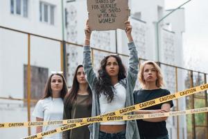 vi kommer att stå här tills du hör oss. grupp feministiska kvinnor protesterar för sina rättigheter utomhus foto