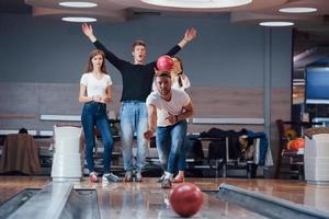 lycka till. unga glada vänner har kul i bowlingklubben på sina helger foto
