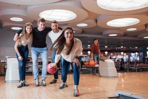 upphetsade människor. unga glada vänner har kul i bowlingklubben på sina helger foto