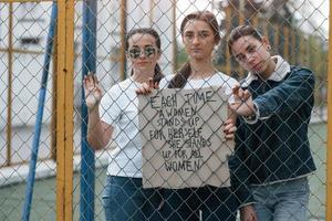 citat på tidningen. grupp feministiska kvinnor protesterar för sina rättigheter utomhus foto