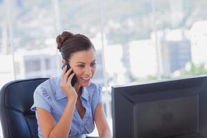 glad affärskvinna som ringer och arbetar på sin dator