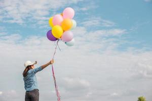 vacker flicka hoppar med ballonger på stranden foto