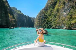 kvinna turist på båttur, glad resenär avkopplande vid pileh lagunen på phi phi island, krabi, thailand. exotiskt landmärke, destination sydöstra Asien resor, semester och semester koncept foto