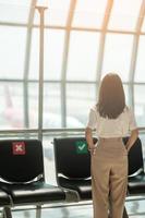 ung kvinna turist vid internationella flygplatsterminalen. tid att resa, resa och semester koncept foto