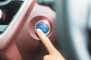 fingertryck på en bils tändningsknapp eller starta motorn i en modern elbil. nyckellöst, förändring, strategi, vision, innovation och framtidskoncept foto