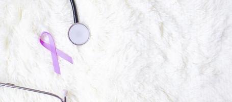 värld cancerdagen. lavendel lila band med stetoskop för att stödja människor som lever och sjukdom. hälsovård och medicinsk koncept foto