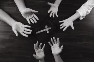 händer på ungdomar som ber med kors på bordet, koncept av hopp, tro, kristendom, kyrka online. foto