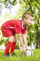 ung pojke som håller fotboll foto