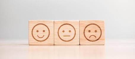 känslor ansikte symbol på trä block. servicebetyg, ranking, kundrecension, nöjdhet, utvärdering och återkopplingskoncept foto