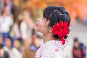 ung kvinna turist bär kimono njuter med färgglada löv i kiyomizu dera tempel, kyoto, japan. asiatisk tjej med frisyr i traditionella japanska kläder under höstens lövverk säsong foto