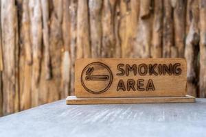 förbjudet rökområde träskylt placerad på ett cementbord foto