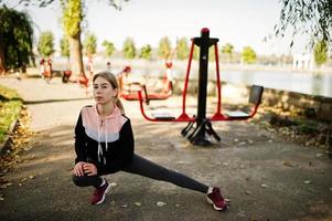 ung flicka tränar och tränar utomhus på gatusimulatorer. sport, fitness, street workout koncept. foto